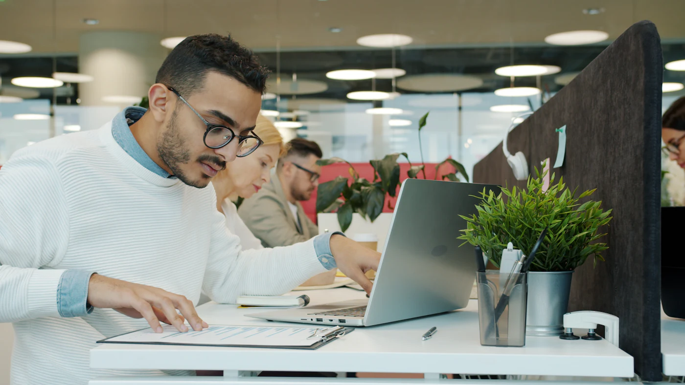 An accountant working through paperwork at a desk in a bright office