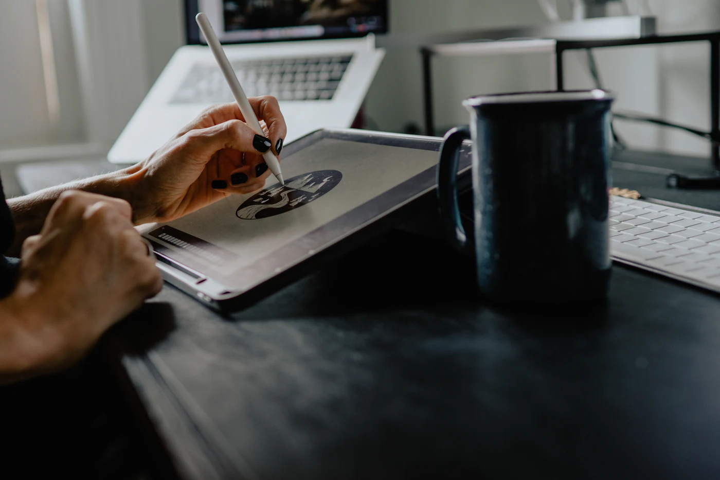 A designer sketching a circular logo on a tablet with a stylus