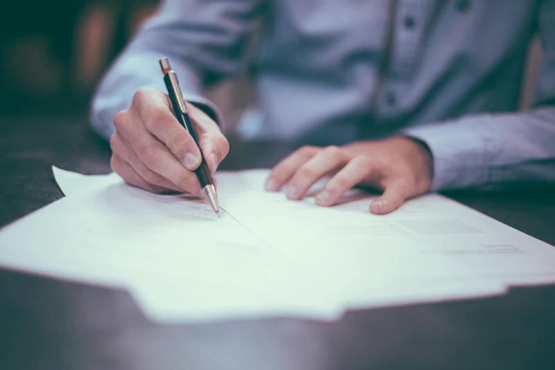 A solicitor's hand annotating a document with a pen