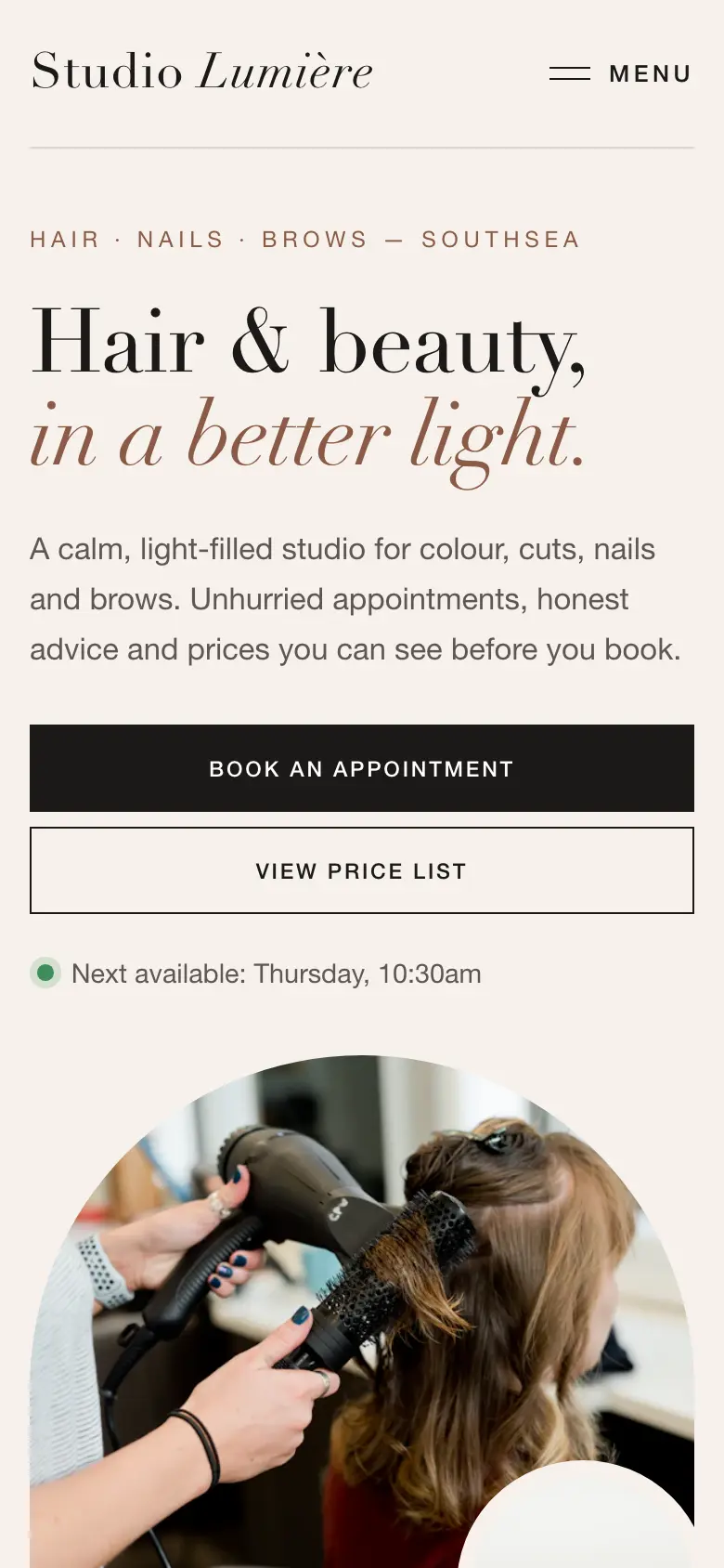 The Studio Lumière salon concept website on a phone, showing the headline, booking and price list buttons and the next available appointment